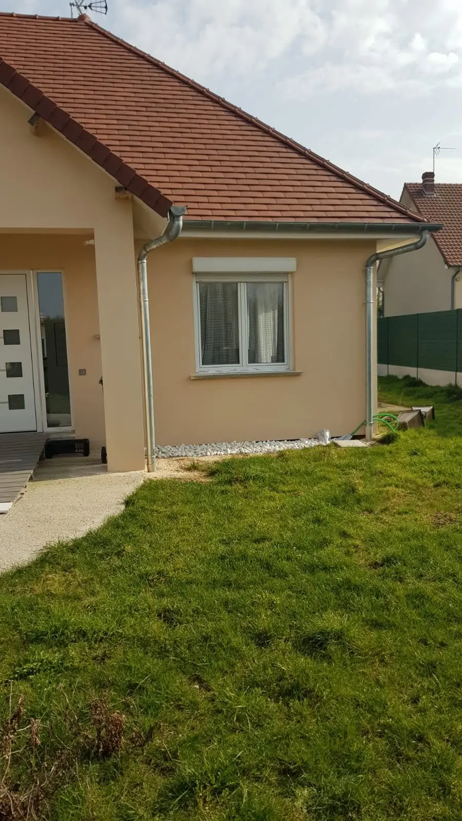 Maison rénovée avec façade claire et toiture en tuiles